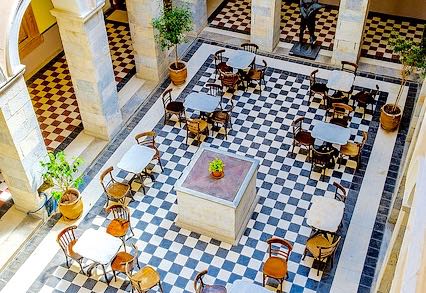 Have a coffee in the beautiful marble courtyard inside the Town Hall of Ermoupolis. One of the best things to do in Syros.